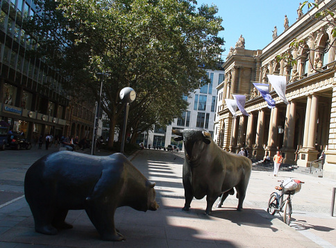 Frankfurt, Germany - August 30, 2016: Scenery Of Bear And Bull Statue At Main Entrance Of Frankfurt Stock Exchange Building Of The Deutsche Boerse AG Located In The City Center Of Frankfurt Hesse Germany In Western Europe.Including People Sitting Down,Walking,On A Beautiful Day In Summertime.Including Business Logos On The Wall Of Close By Buildings And Parked Land Vehicle And Bicycle