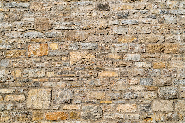 istock Old and weathered wall made out of different stones 599246342