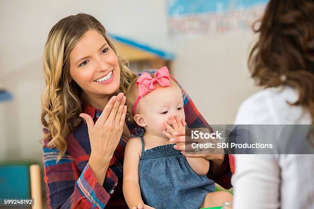 Smiling Mother And Her Cute Toddler Daughter Practicing Sign Language Stock Photo - Download Image Now