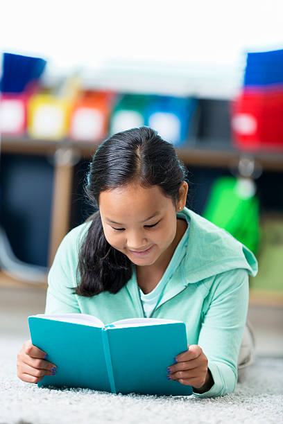 istock Happy Asian student reads book in library 599248218