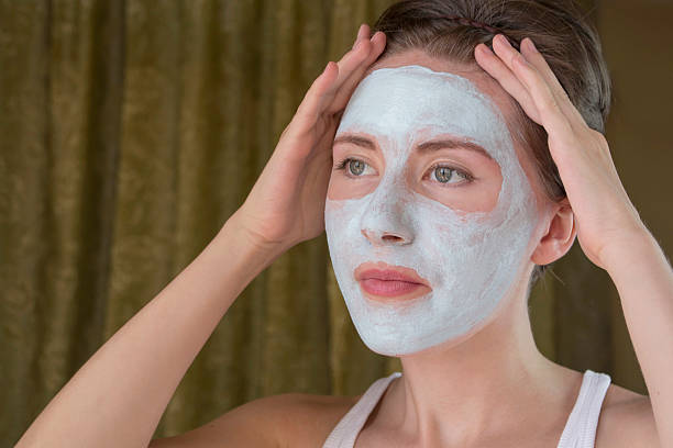 istock woman doing cosmetic mask on her face 599255860