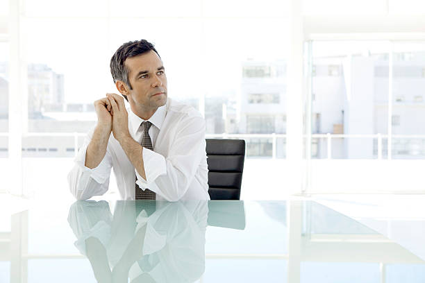 hombre de negocios pensativo sentado en la sala de juntas - thinking business ceo board room fotografías e imágenes de stock