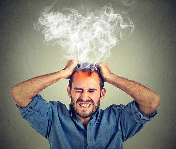 stressed man having headache steam coming up - heat effort emotional stress business imagens e fotografias de stock