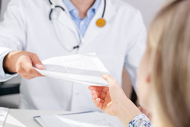 istock doctor give a document to patient 599266386