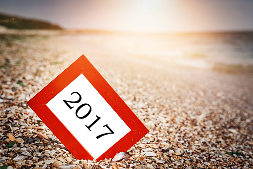 red frame with 2017 year written on it, New Year and holiday concept, photo taken on the beach at sunset.