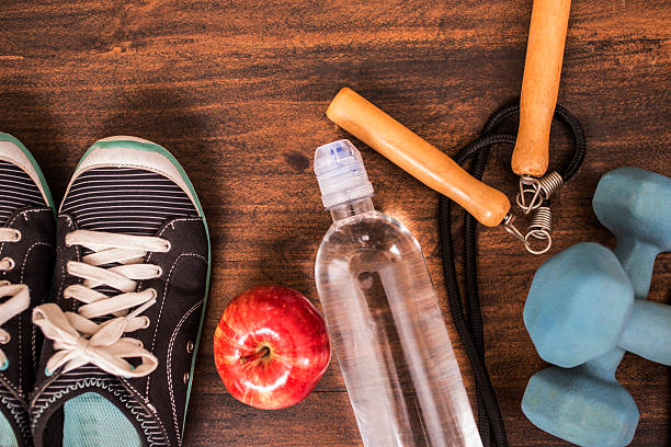 istock Fitness, exercise themed scene with weights, sneakers, apple. 599267126