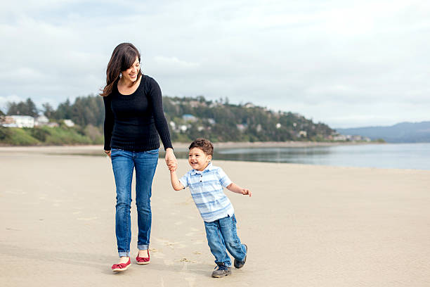 istock Beautiful ethnic mother holds her sons hand 599271180