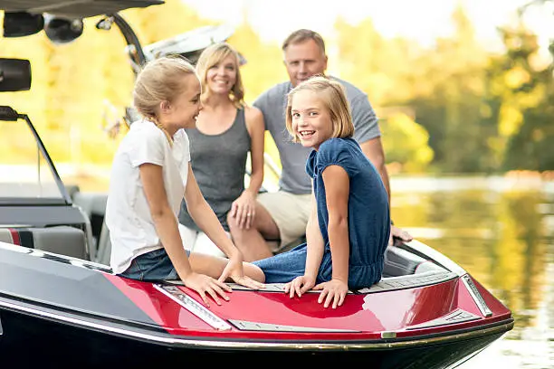 Beautiful young family sits in their ski boat ready to go skiing