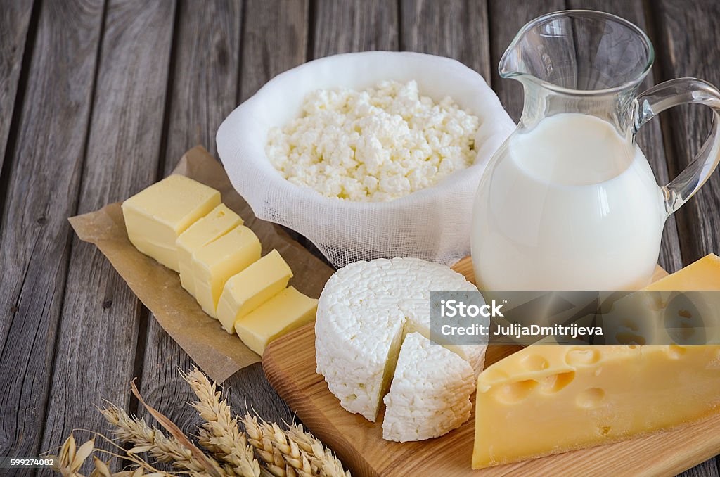 Fresh dairy products - milk, cheese, butter and cottage cheese Fresh dairy products - milk, cheese, butter and cottage cheese with wheat on rustic wooden background, selective focus, copy space Dairy Product Stock Photo