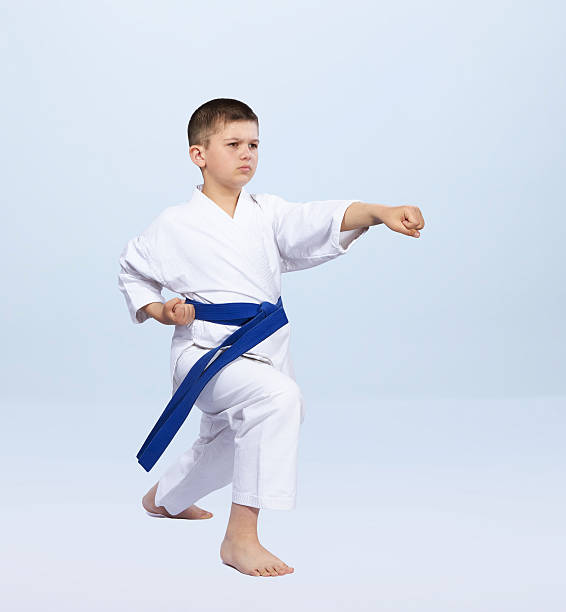 istock Boy in karategi beats punch arm on a light background 599275184