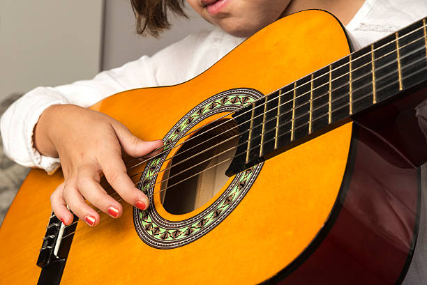 istock Little girl playing guitar 599275548