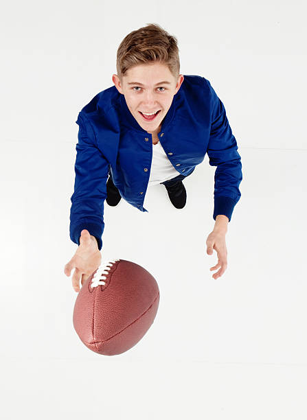 istock Smiling male throwing American ball 599275904
