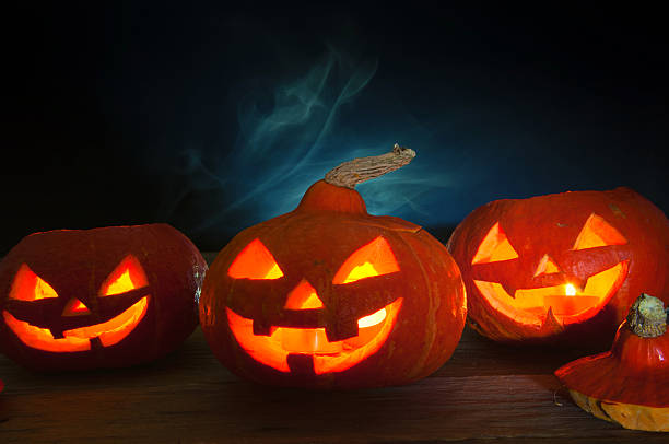 istock Scary halloween pumpkins on dark background 599276246