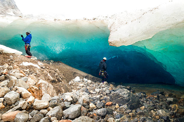 istock Two males prepare rappelling rope for ice cave 599276606