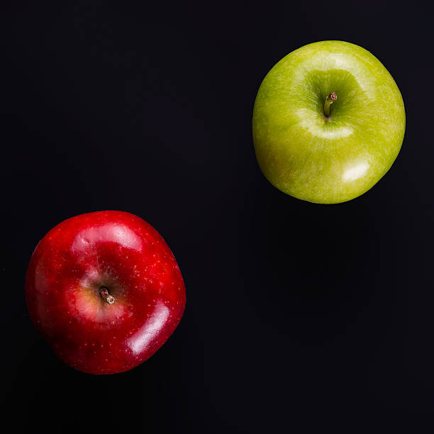 único. manzana roja entre el grupo de manzanas verdes. - individuality standing out from the crowd apple contrasts fotografías e imágenes de stock