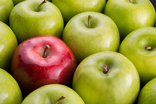 istock Unique. Red apple among group of green apples. 599280148