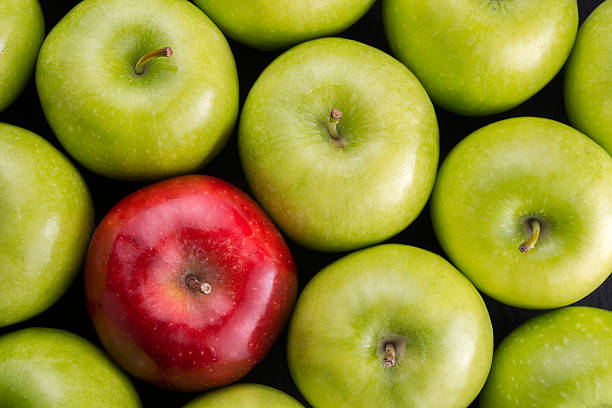 istock Unique. Red apple among group of green apples. 599280248