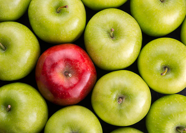 istock Unique. Red apple among group of green apples. 599280324
