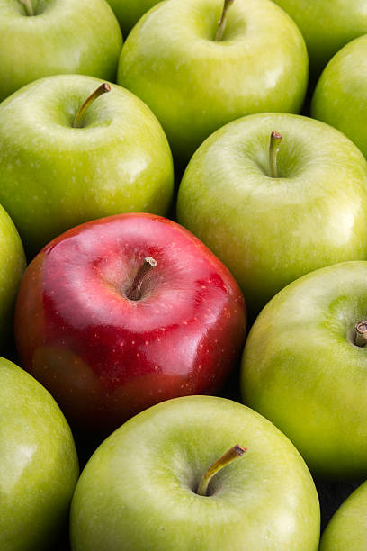 istock Unique. Red apple among group of green apples. 599280504