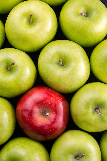 istock Unique. Red apple among group of green apples. 599280748