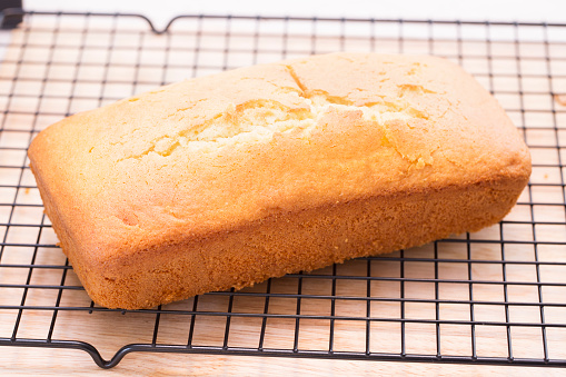 Lemon pound cake loaf cooling on rack.