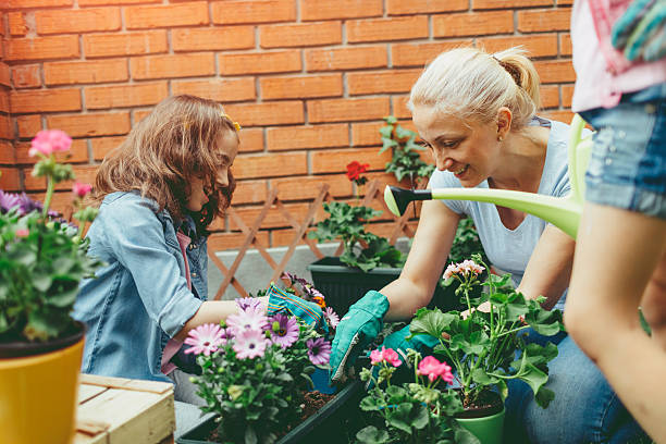 istock Mother And Daughters Planting Flowers Together. 599283370