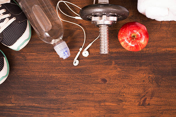 istock Fitness, exercise themed scene with barbells, sneakers, apple. 599460850