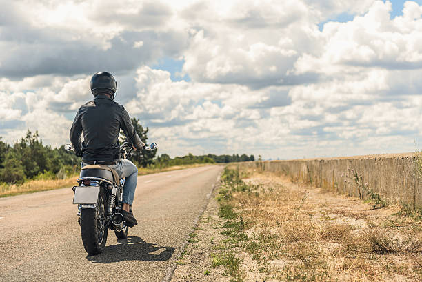 istock Young man riding his motorbike on open road 599461670