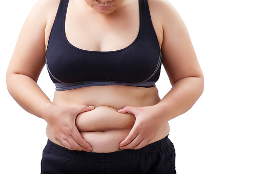 mujer gorda mirando y tocando su estómago photo