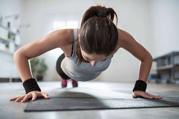 Hard Workouts Young athletic woman doing push-ups. push ups stock pictures, royalty-free photos & images