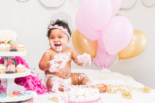 Cute Baby Girl Sitting With Cake and Balloons