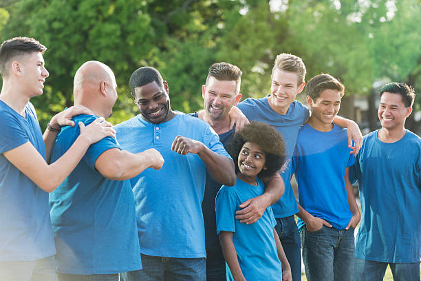 istock Multi-racial group of fathers and sons in blue shirts 599471136