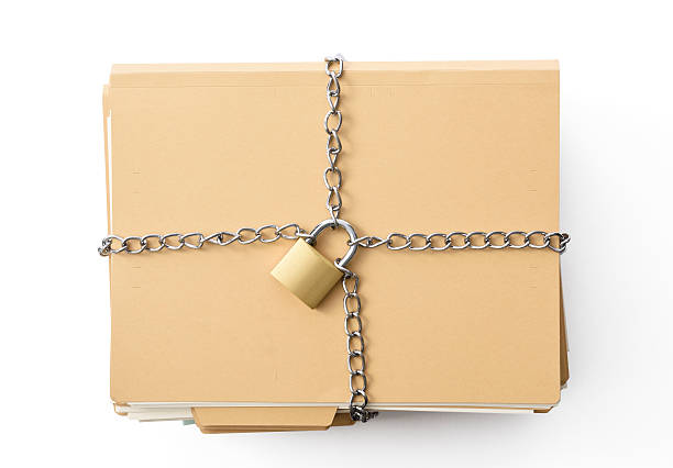 istock Stacked file folder and tied up chain with locked padlock 599474606