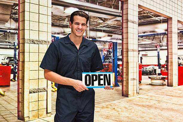 istock Smiling mechanic holding open sign 599480512