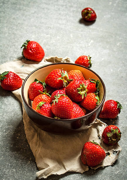 istock Ripe strawberries in bowl on old fabric. 599483454