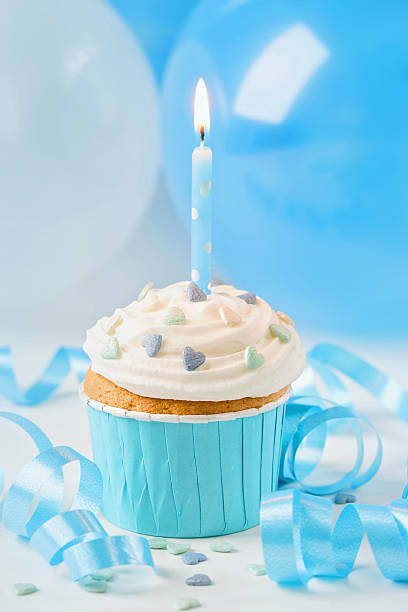 istock Blue cup cake with birthday candle 599484608