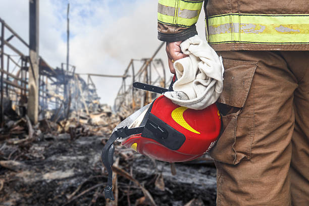 istock Firefighter holding red safety helmet isolated on white 599486208