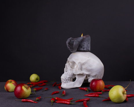Halloween festival. Still life with skull, candle, apples and red pepper