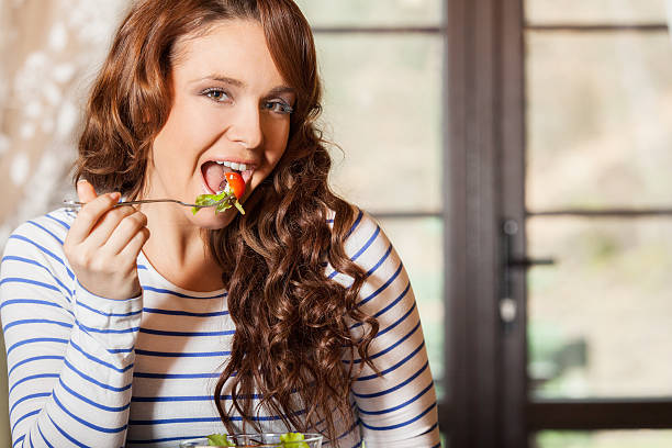 istock Woman eating fresh vegetable salad 599489014