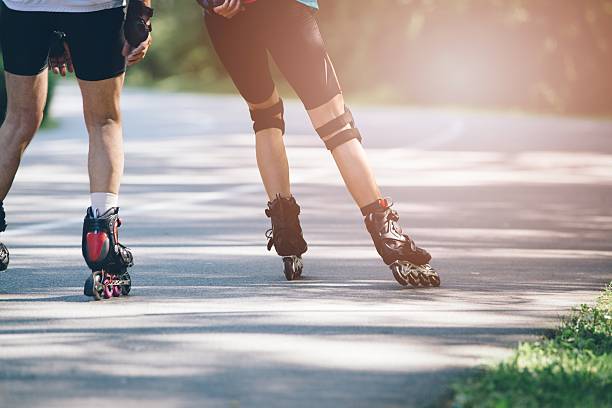 rollerblading su strada asfaltata. - pattinaggio in linea foto e immagini stock