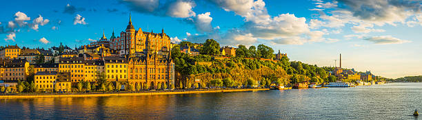 Stockholm golden sunset light on iconic waterfront of Sodermalm Sweden The historic townhouses, apartment buildings and boats along the Sodermalm waterfront illuminated by warm early morning sunlight overlooked by the hilltop lookout of Skinnarviksparken under summer sunset skies, Stockholm, Sweden. sodermalm photos stock pictures, royalty-free photos & images