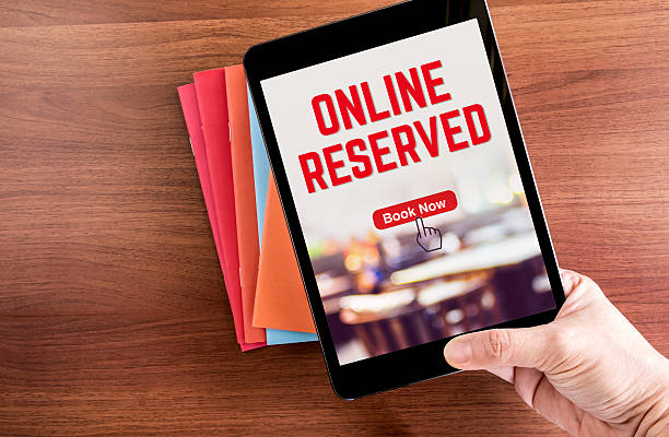 istock Top view of hand holding tablet with online reserved 599490722