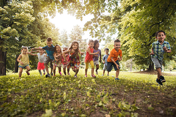 istock Group of playful children having fun while running in nature. 599492416