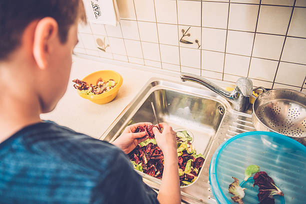 niño de doce limpieza radicchio en la cocina del hogar, europa - leaf vegetable salad child spring fotografías e imágenes de stock