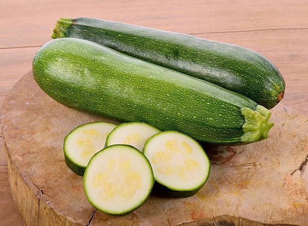 istock green zucchini vegetables on wooden background 599493474