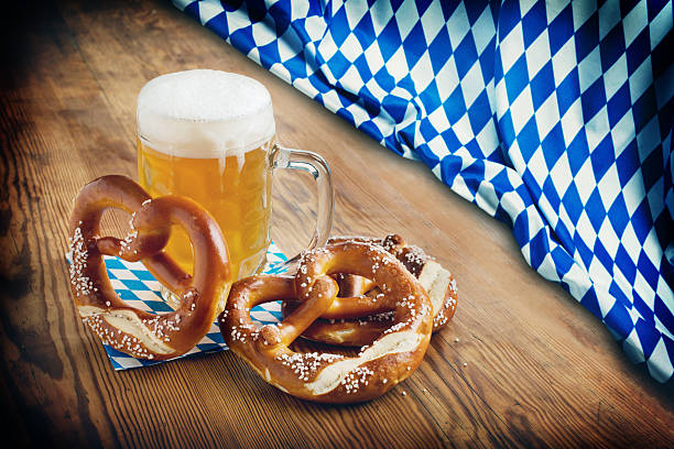 Beer Fest Background â€“ Beer and Pretzel Beer glass and pretzel on wooden table oktoberfest beer stock pictures, royalty-free photos & images