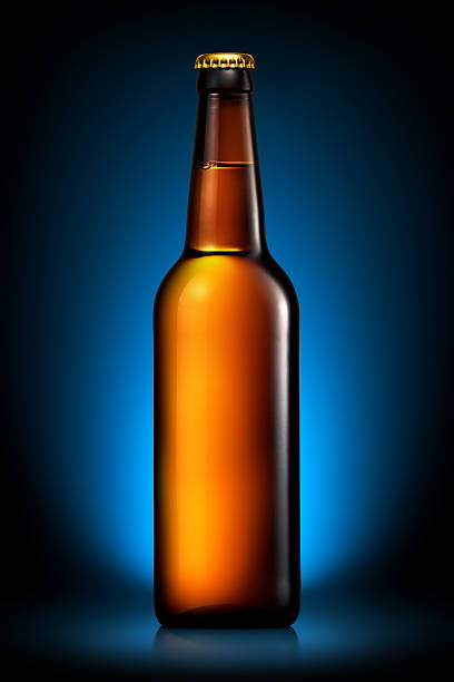 istock Bottle of beer or cider isolated on dark blue background 599493906
