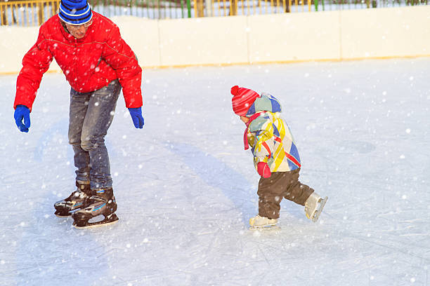 istock father teaching little daughter to skate in winter 599498182