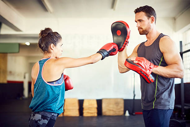 istock Confident female fit boxer practicing with instructor in gym 599499252