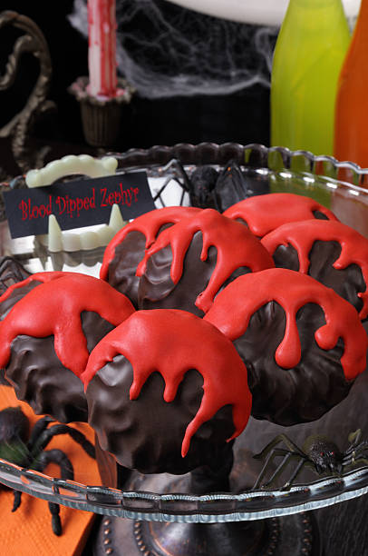 Blood dipped zephyr Zephyr in chocolate glaze with a bloody streaks   the table on Halloween sunken cake stock pictures, royalty-free photos & images